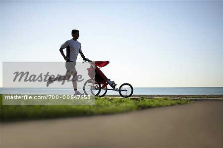 Homme avec un enfant dans la poussette de Jogging