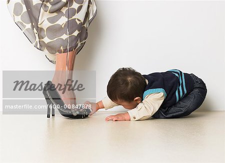 Bébé garçon fasciné par les chaussures de la mère