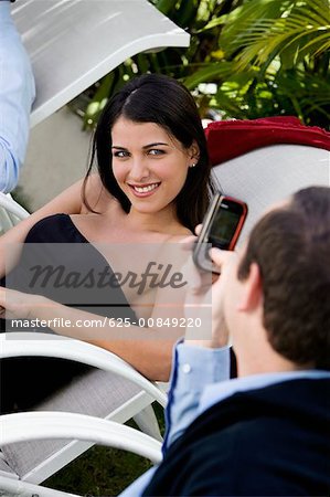 Close-up of a businessman taking a picture of a businesswoman