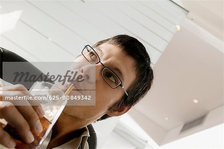 Close-up of a businessman sipping a drink with a straw