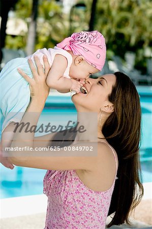 Side profile of a young woman picking up her daughter