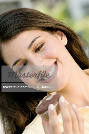 Close-up of a young woman holding a muffin