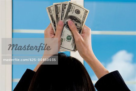 Vue arrière d'une femme d'affaires holding américaine de papier-monnaie