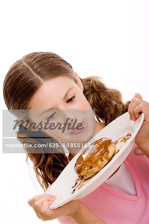 Gros plan d'une jeune fille tenant une assiette dessert