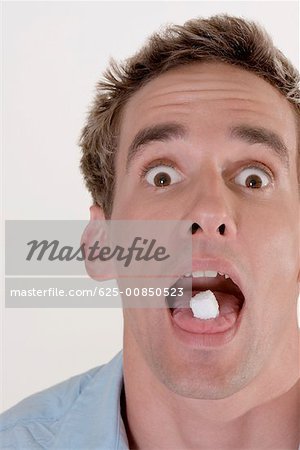 Portrait d'un jeune homme avec des bonbons dans la bouche