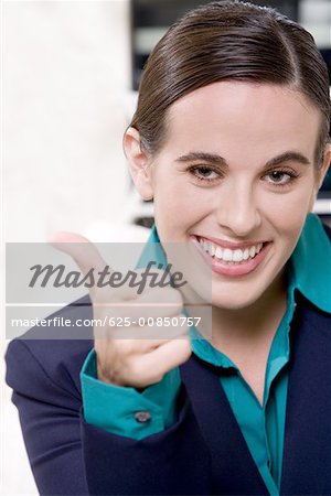Portrait d'une femme d'affaires qui signe un pouce en l'air