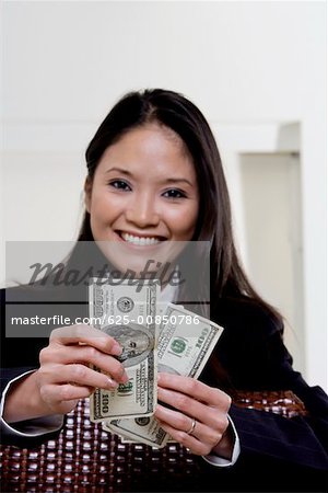 Portrait d'une femme d'affaires détenant des billets de cent dollars
