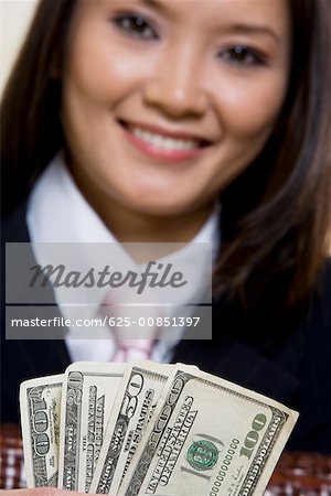 Portrait d'une femme d'affaires détenant des billets de cent dollars