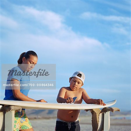 Brother and Sister Waxing Surfboard