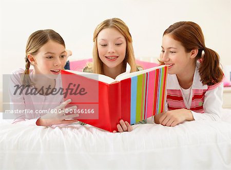 Girls Lying on Bed, Reading Book