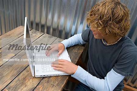 Teenage boy working on a laptop computer