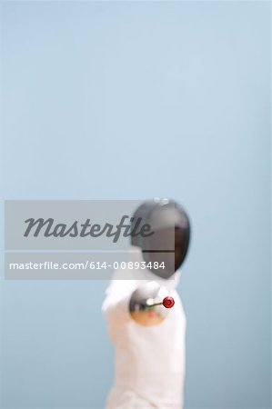 Garçon en tenue avec l'épée d'escrime Garçon en tenue avec l'épée d'escrime
