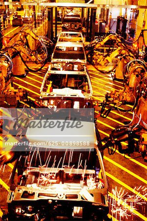 High angle view of robotic arms working on cars in an assembly line, Michigan, Maryland, USA