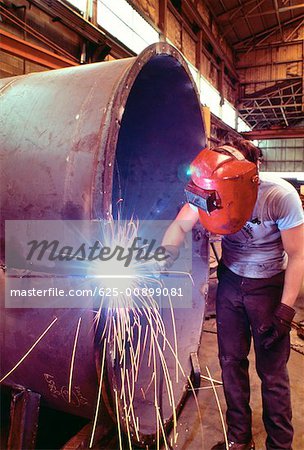 Welder welding a large tank Welder welding a large tank