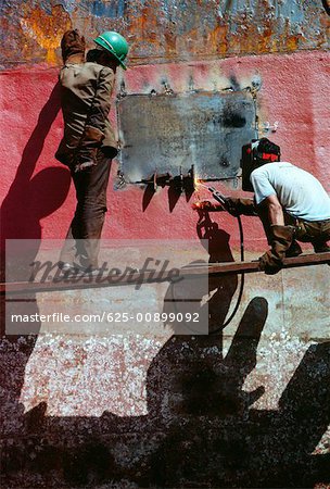 Low angle view of two men welding a tanker, Cebu, Philippines Low angle view of two men welding a tanker, Cebu, Philippines