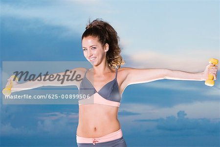 Portrait of a young woman exercising with dumbbells