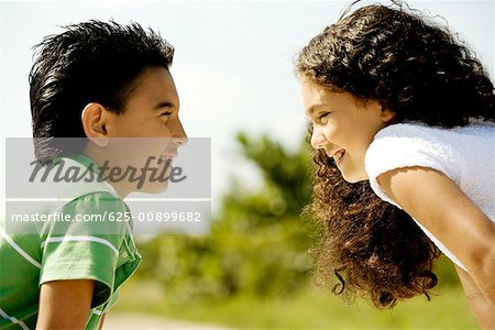 Close-up of a boy and a girl looking at each other smiling