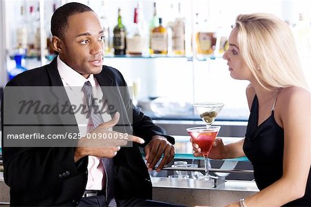 Close-up of a businessman and a young woman at a bar counter