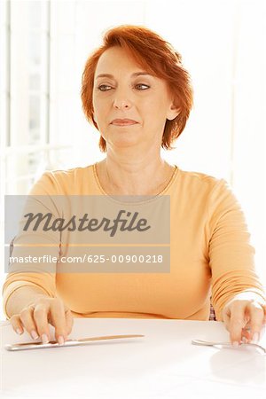 Close-up of a senior woman seated at the table looking away