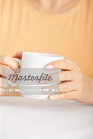 Mid section view of a senior woman holding a coffee cup