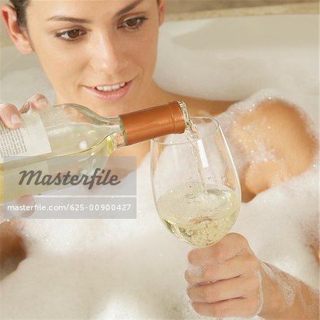 Close-up of a young woman pouring champagne in a champagne flute