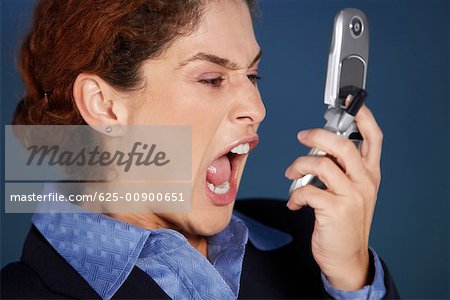 Close-up of a businesswoman holding a mobile phone and shouting