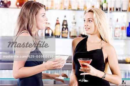 Gros plan des deux jeunes femmes tenant des verres de cocktail