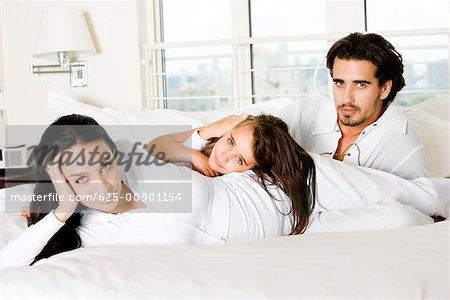 Parents with their daughter on the bed