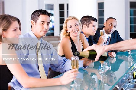 Five people sitting at a bar counter