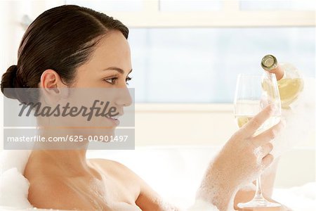 Close-up of a young woman pouring white wine into a wineglass