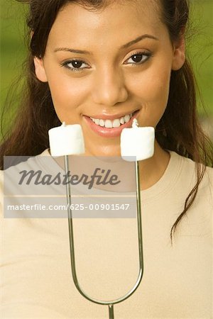 Portrait d'une adolescente qui organise les guimauves sur une brochette