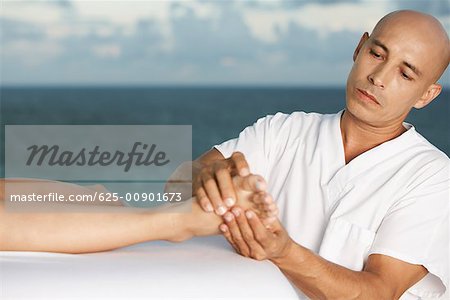 Close-up of a massage therapist massaging a person's foot