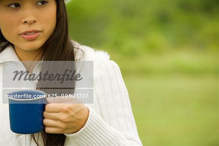 Close-up of a young woman holding a cup of coffee