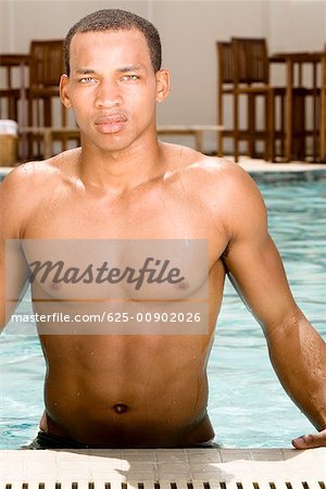 Porträt eines jungen Mannes stehend in einem Schwimmbad