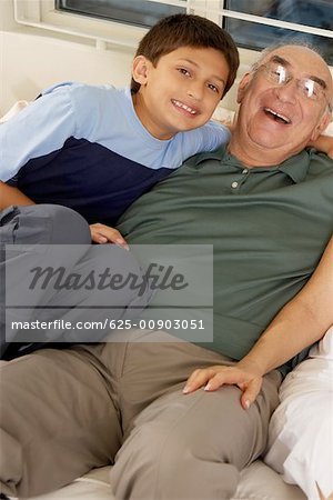 Portrait of a boy and his grandfather on a couch