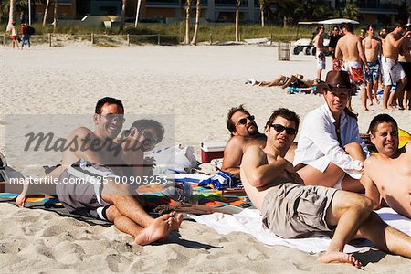 Jeunes hommes et deux jeunes femmes, un bain de soleil sur la beach, South Beach, Miami, Floride, USA