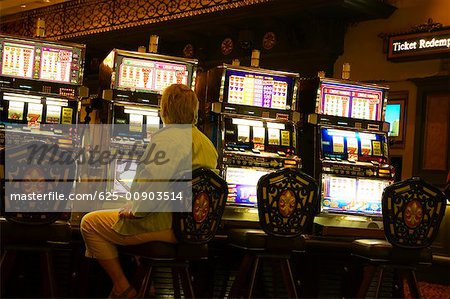 Rear view of a man sitting at a slot machine, New Orleans, Louisiana, USA