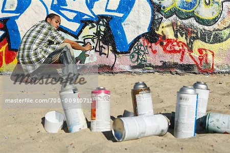 Man Spraying Graffiti on Wall