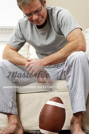 Homme sur le canapé avec le Football