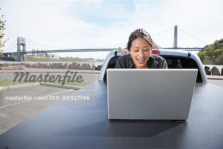 Femme à l'aide d'ordinateur portable sur l'arrière du camion