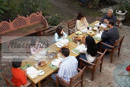 Family Saying Grace Before Dinner Outdoors