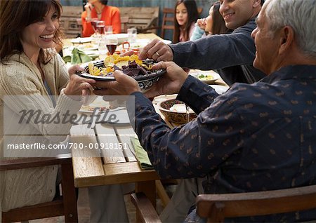 Femme en passant le bol au dîner de famille à l'extérieur