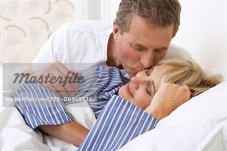 Man Kissing Woman in Bed