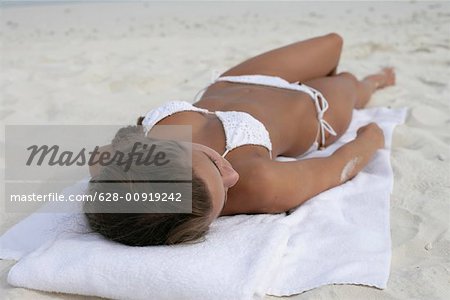 Junges Mädchen im Bikini am Malediven Strand liegend zu tragen