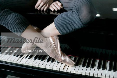 Un danseur de ballet femme assise sur un piano