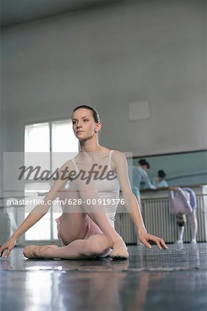 A female ballet dancer sitting in pose on the floor