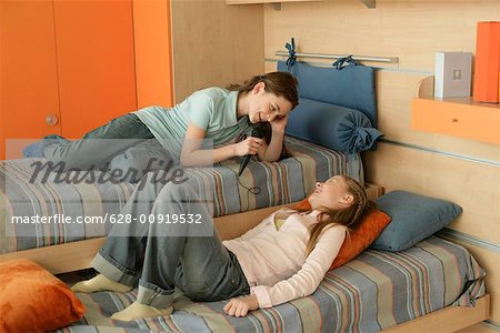 Two friends lying on a bed