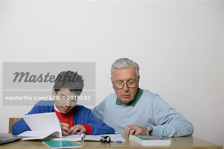 Grandfather and a boy doing homework together, fully_released