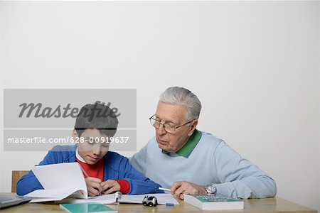 Grandfather and boy doing homework together, fully_released