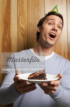 Man Holding Slice of Birthday Cake with Candle